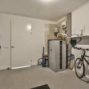 Spacious garage with closed door and white walls with hangers on it