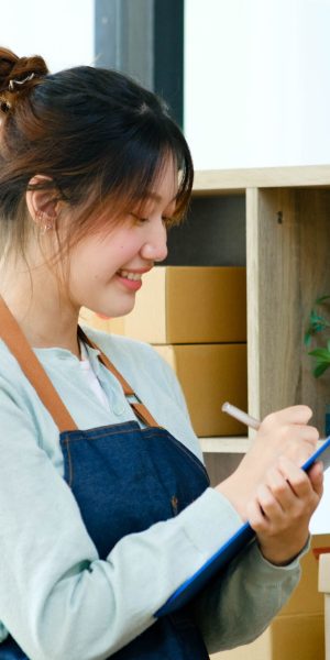 Young businesswoman start up checking inventory in small business.Businesswoman checking inventory in stock room. Store house inspection.