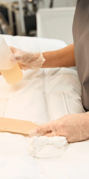 Close-up dry-cleaning operator identifying stains and applying removal agent to clean the item with brush, professional dry-cleaning service